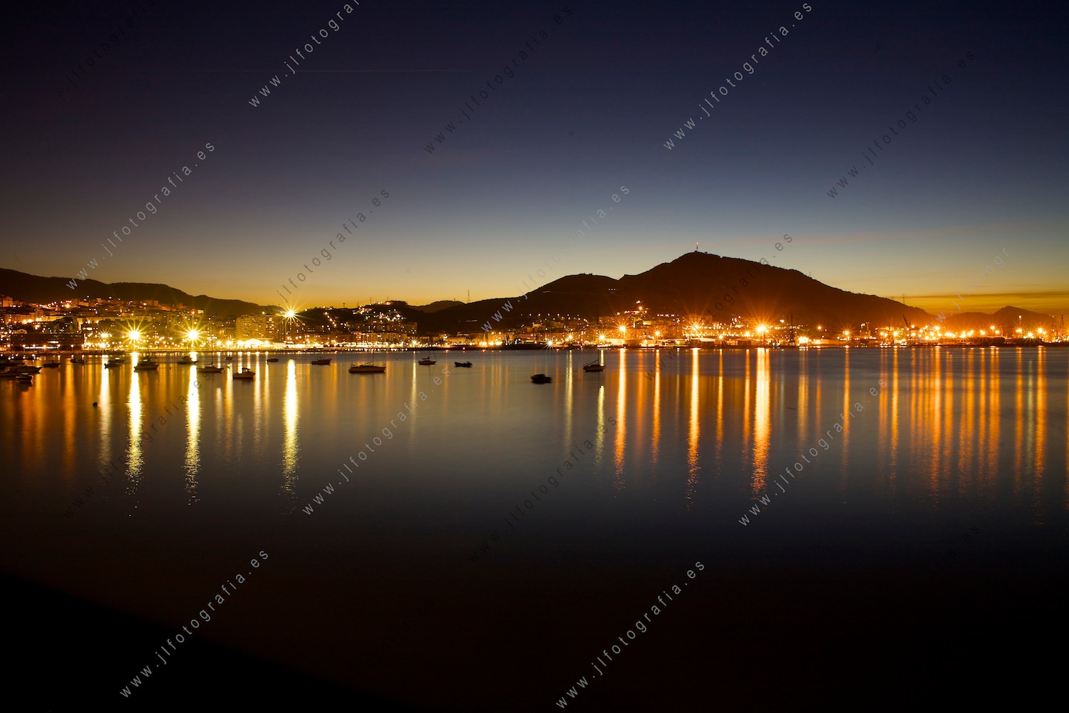 Fotografía paisaje de Santurtzi desde Gexto en el comienzo de la noche, con el puerto y el monte Serantes