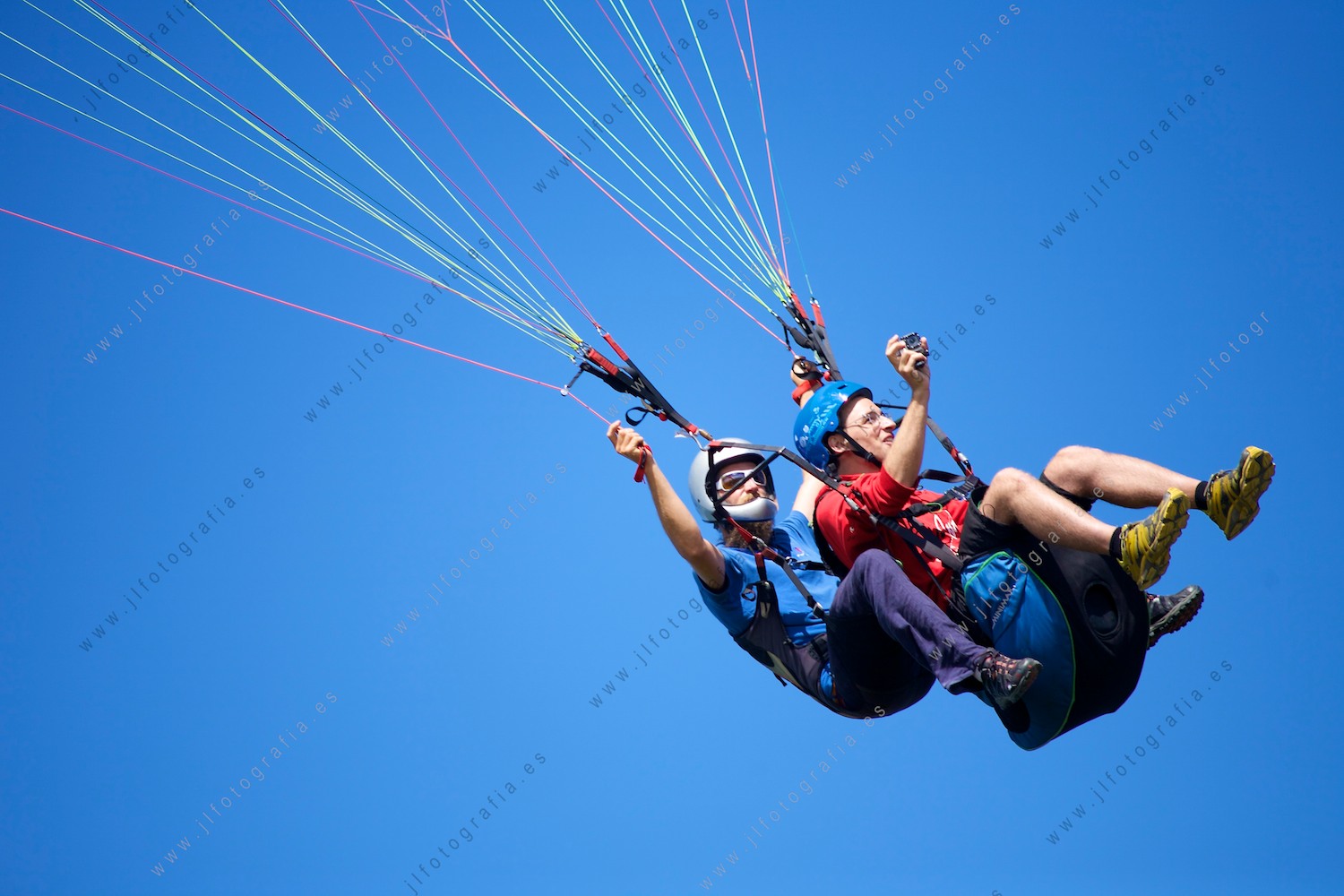 detalle de dos parapentistas volando por el cielo mientras se graban con una GoPro