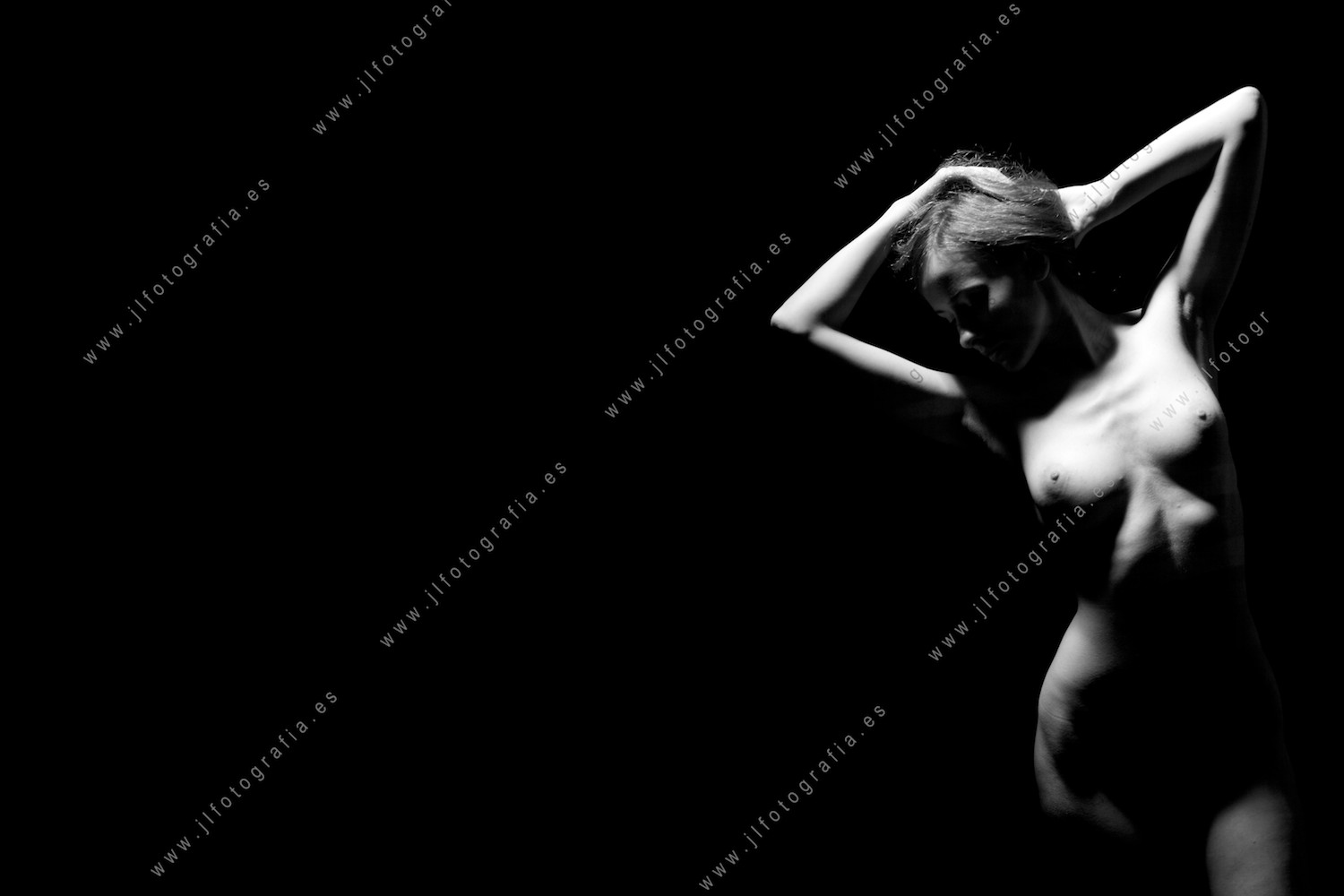 Retrato de estudio de cuerpo desnudo de una modelo iluminada con luz cenital