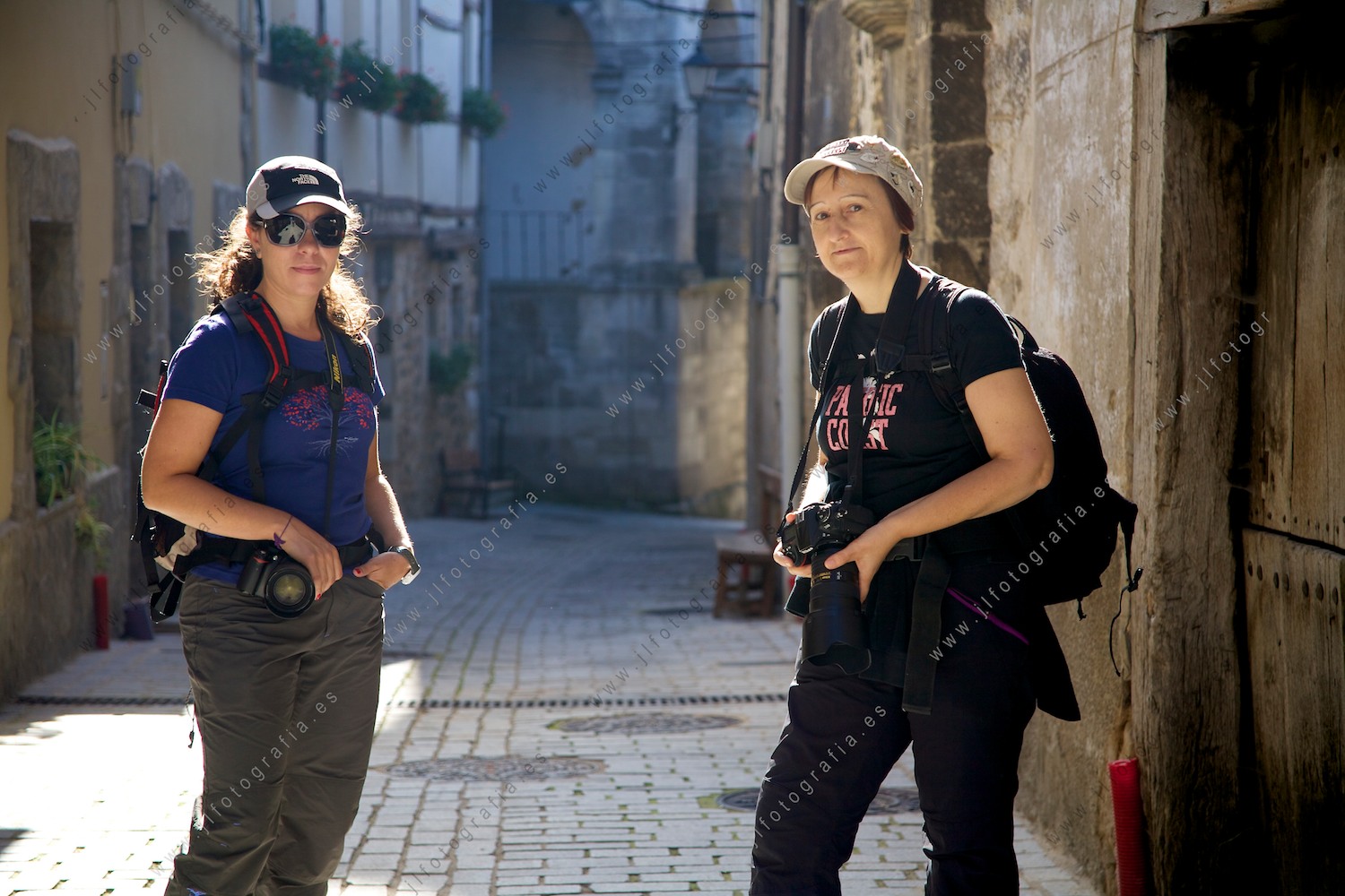 Retrato en contraluz de dos compañeras fotógrafas de Denbora en una de las calles de Antoñana