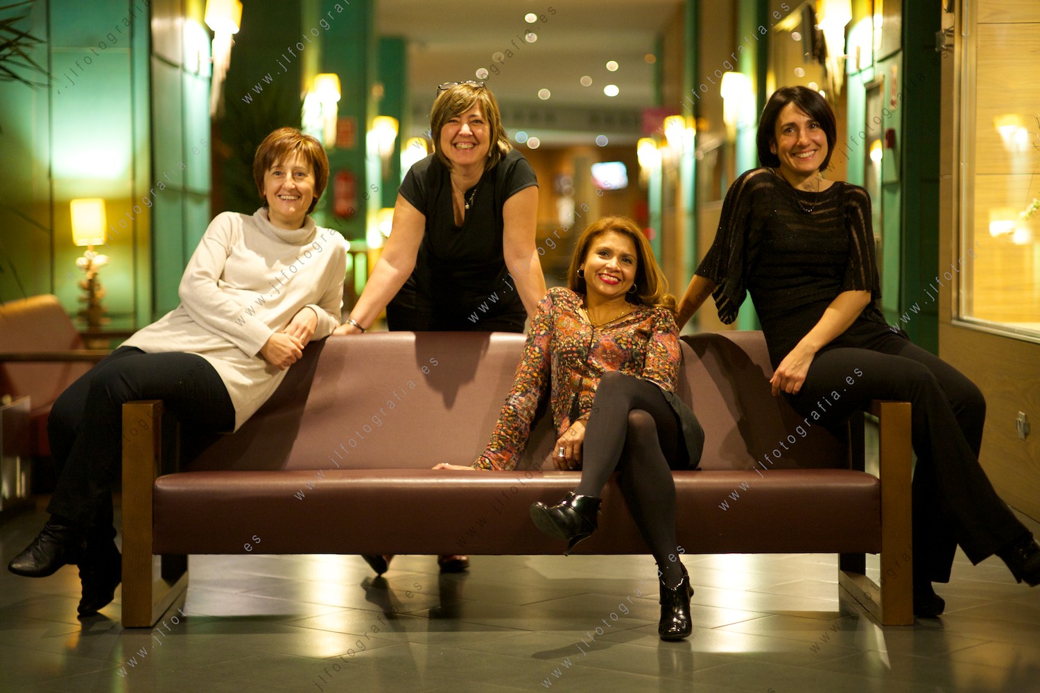 Grupo de señoritas, socias de Denbora, posando en un sofá,en el pasillo del hotel Novotel de Barakaldo