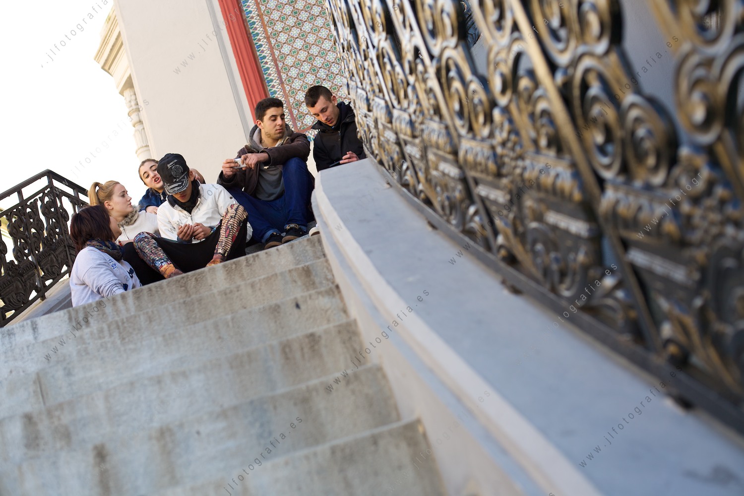 grupo de jóvenes sentados en las escaleras exteriores del mercado de la Ribera 