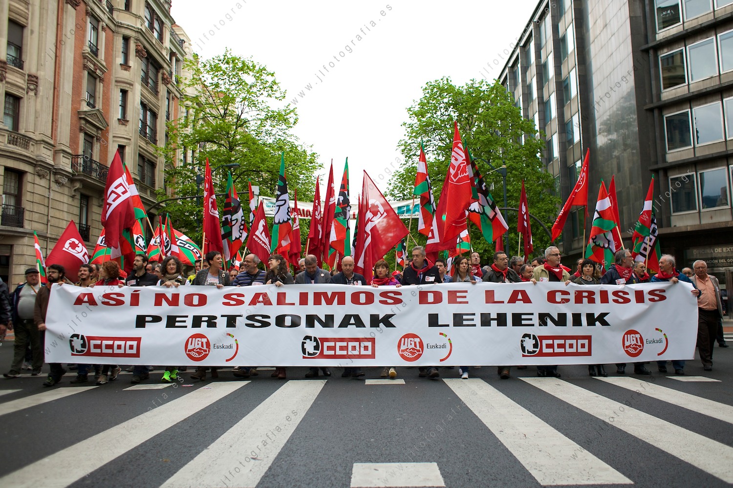 Pancarta de comisiones obreras CC.OO. que decía, Así no salimos de la crisis pertsonak lehenik, en la Gran Vía de Bilbao