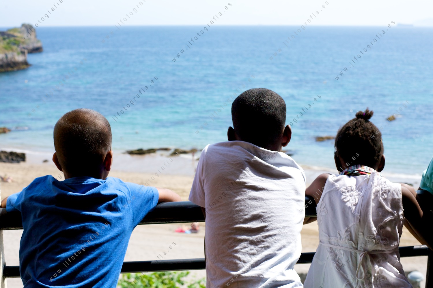 Niños en la terraza mirando al mar