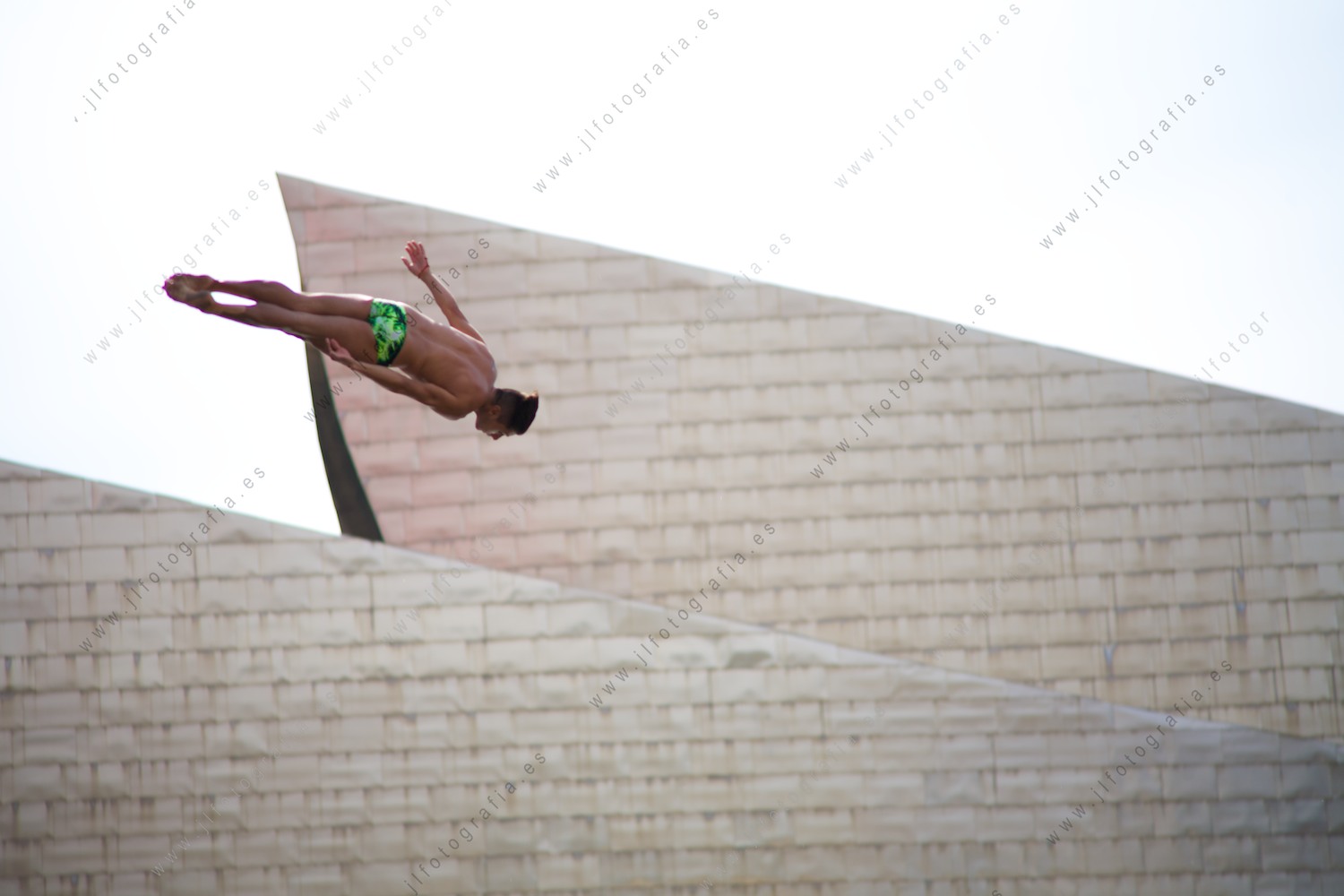 Precioso movimiento frente al museo Guggenheim, de un saltador clavadista en el Red Bull Cliff Diving en Bilbao