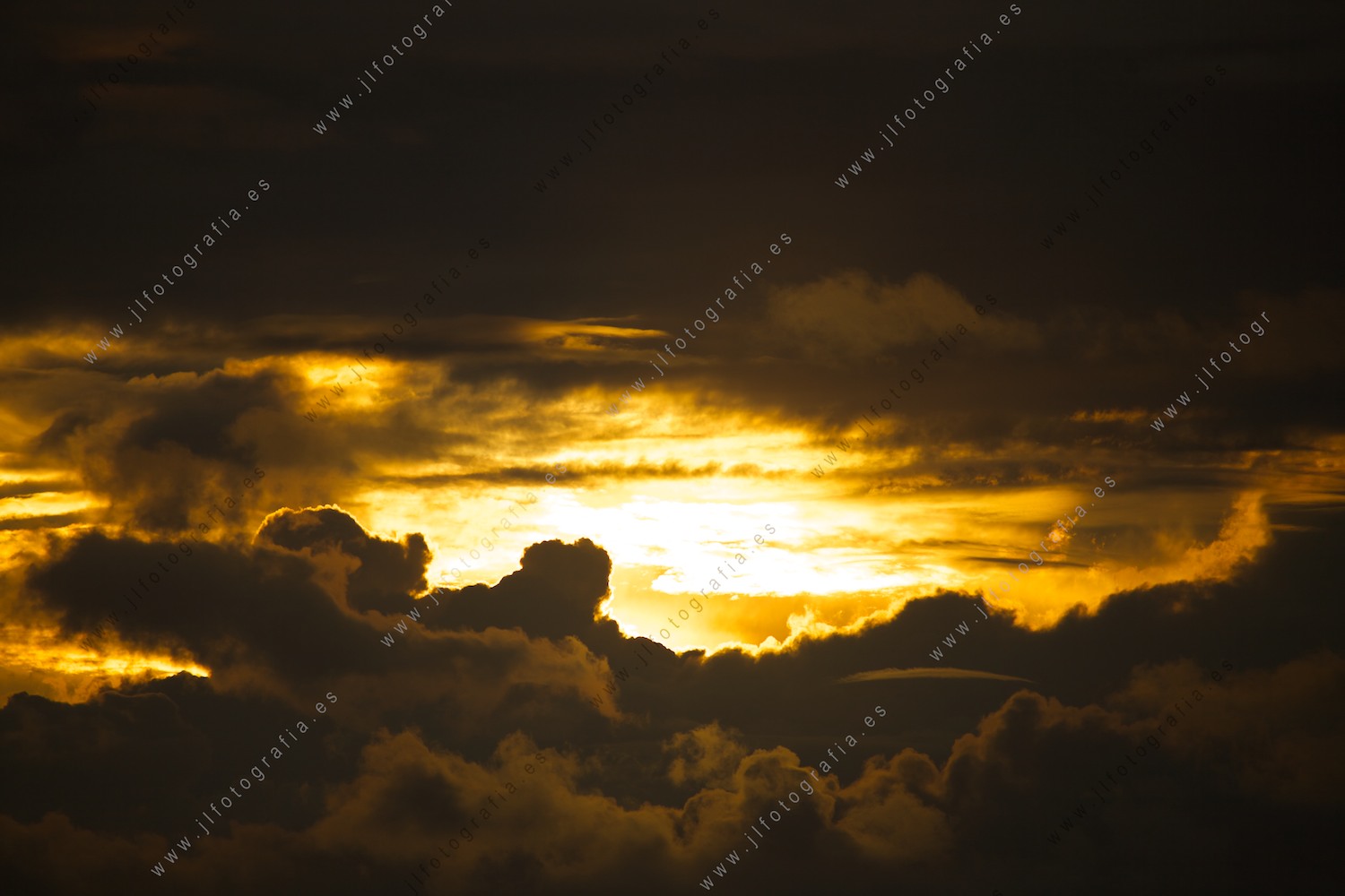 Cielo con las nubes cubriendo la puesta de sol con colores cálidos.