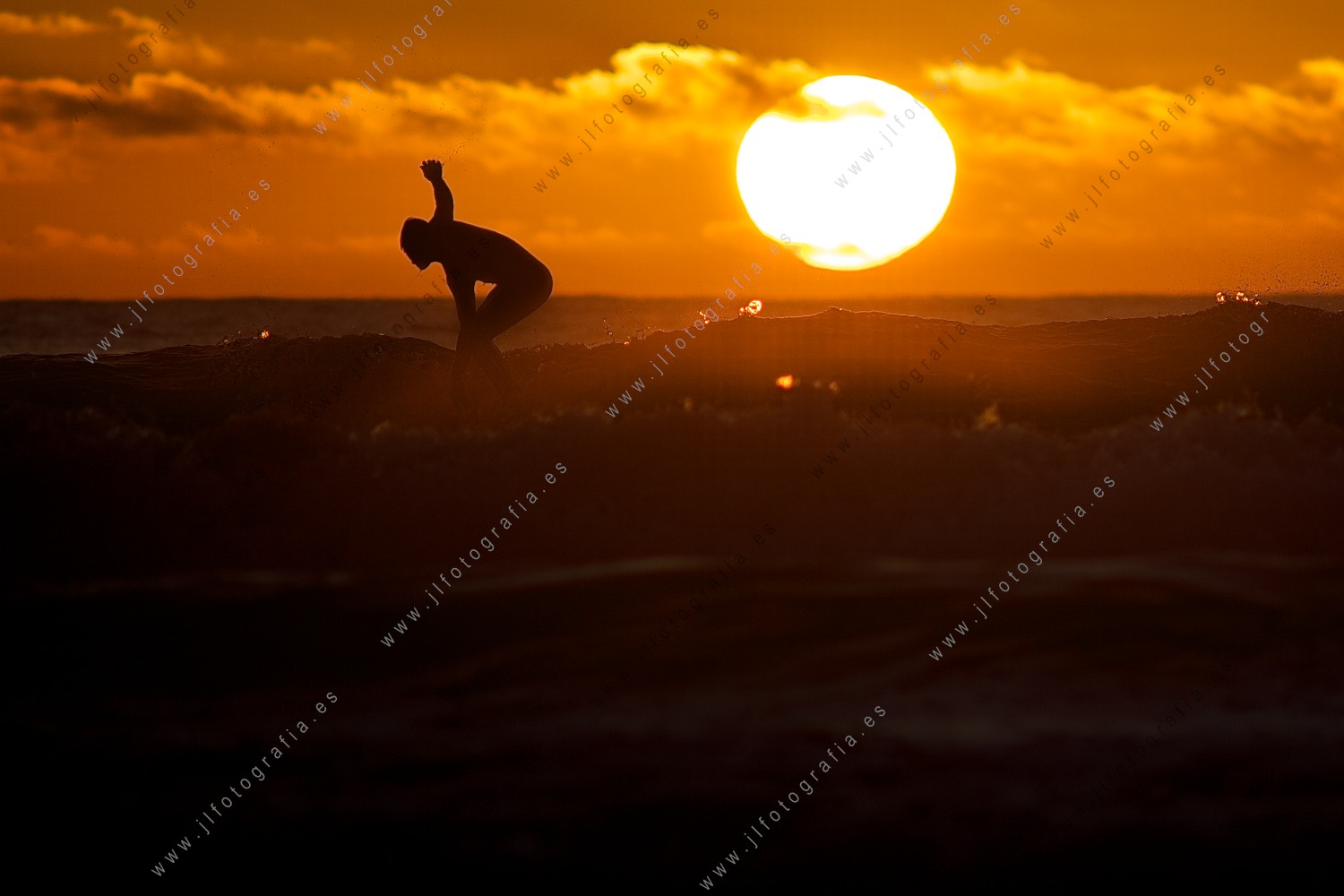 Surfista en las olas que ofrece la playa de Barrika durante el verano en la costa  vasca .