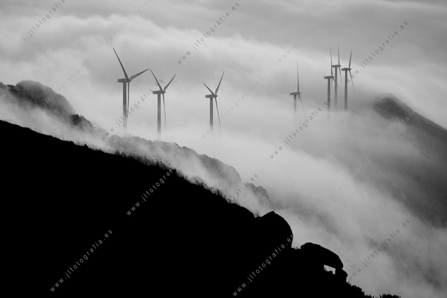 Aerogeneradores en la cresta del monte Oiz, Bizkaia, con un manto de nubes.