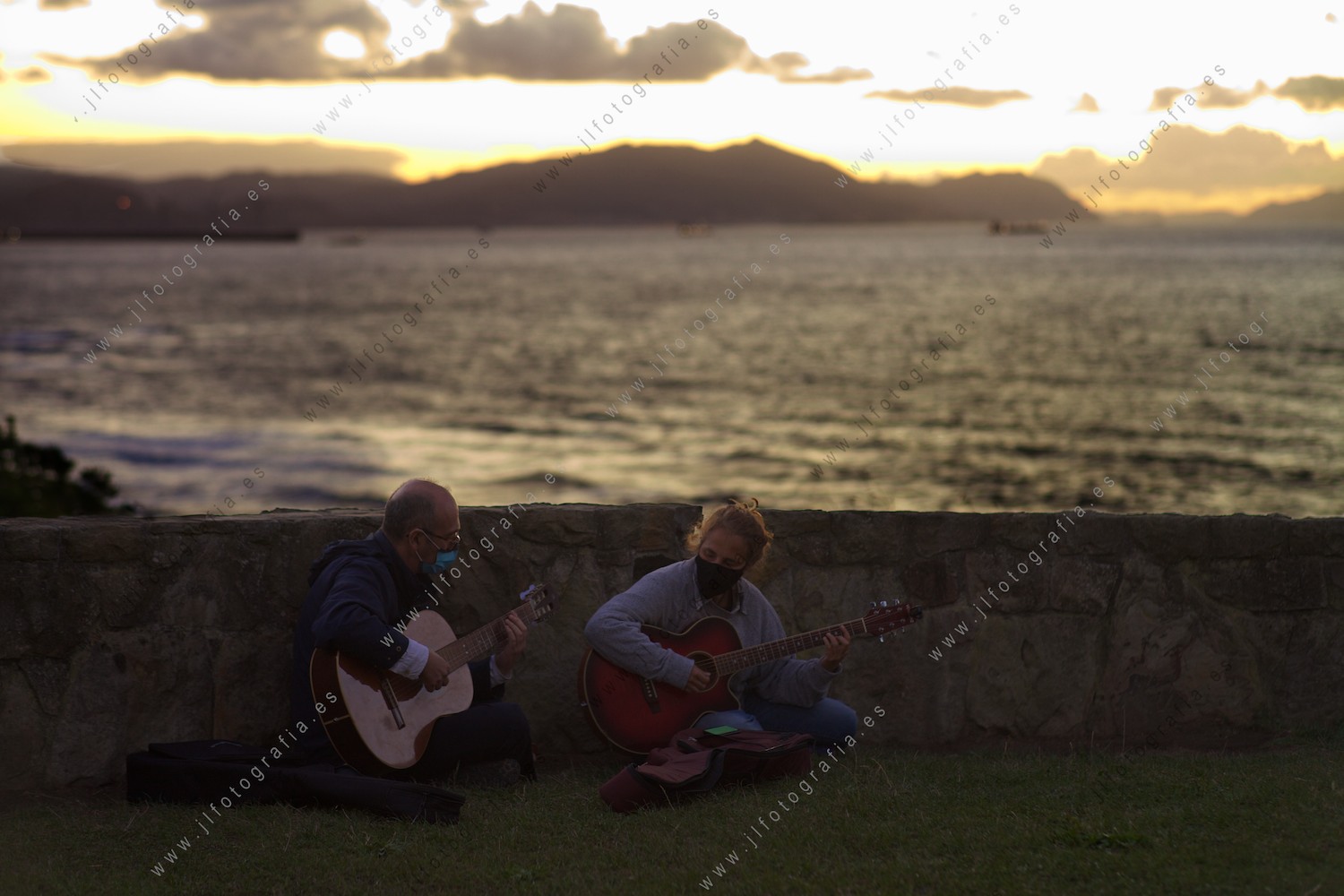 Una pareja de guitarristas disfrutan al acabar el día en los acantilados de Sopelana, Bizkaia.