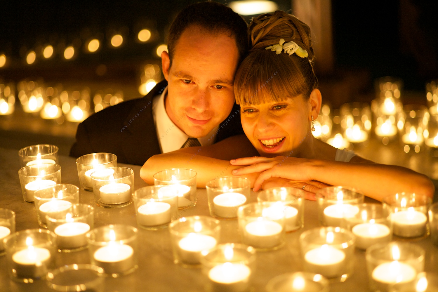 Pareja de novios soñando rodeados de velas, retrato de primer plano del reportaje de boda
