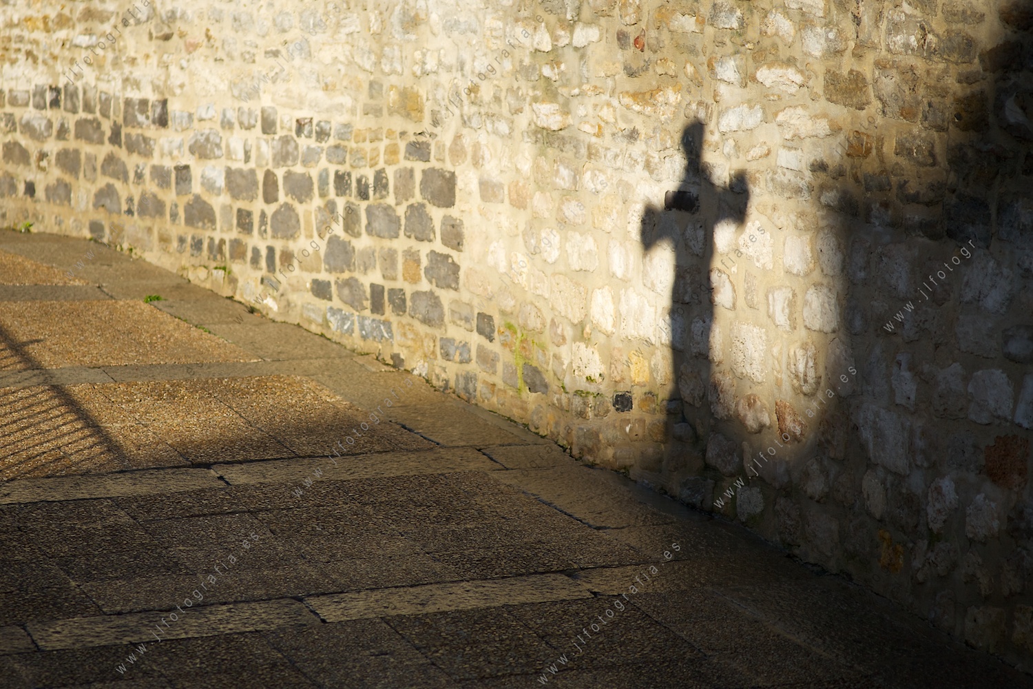 Sombra de una cruz en la calzada romana