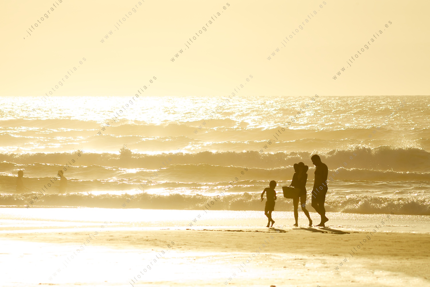 Familia por la playa al atardecer