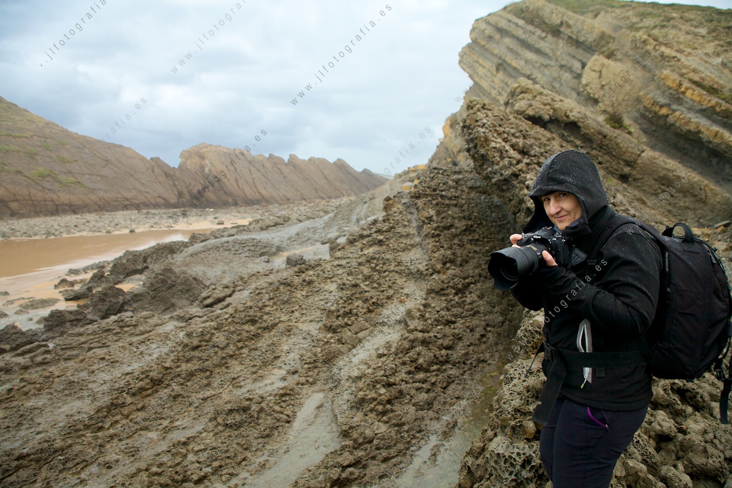 Josune Reoyo, fotógrafa de Denbora en los acantilados de la costa quebrada en Liencre, Cantabria, con su cámara de fotos.