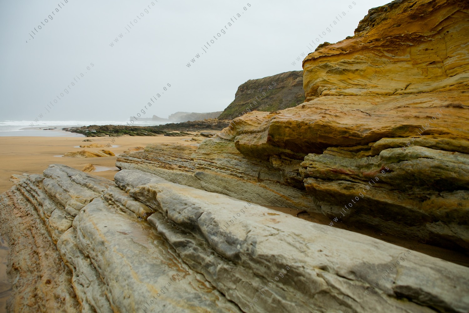 Rocas de los acantilados de la costa quebrada que terminan en la playa de Liencres en Cantabria.