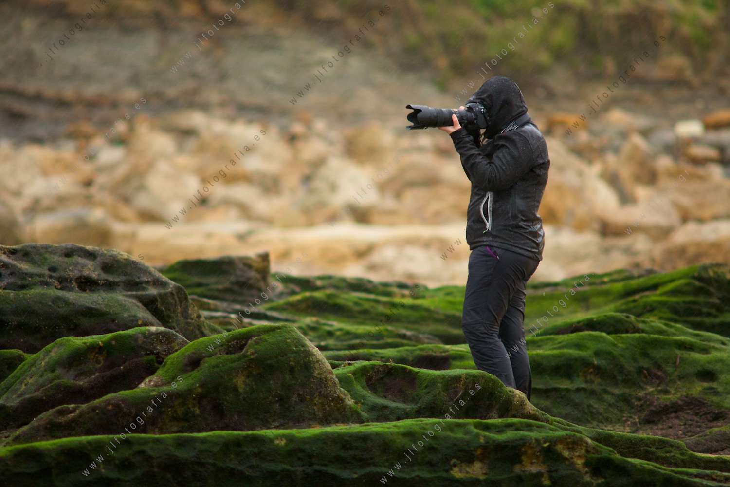 Mi compañera de Denbora, fotografiando bajo la lluvia en la costa quebrada en Liencres, Cantabria.