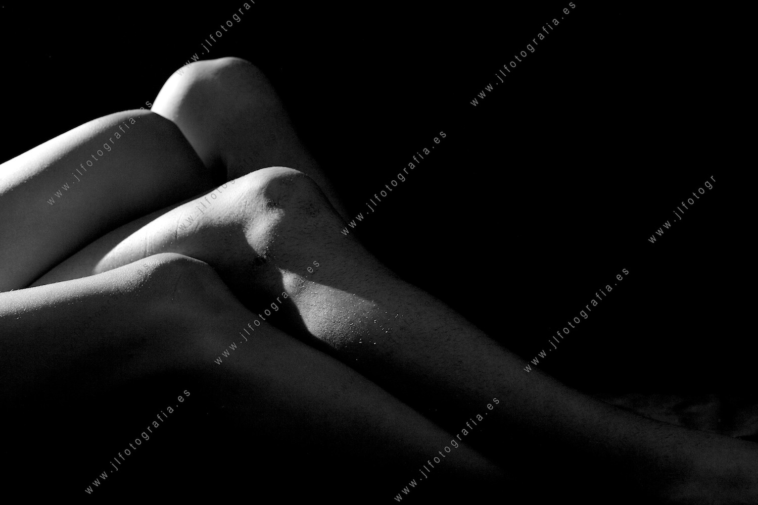 Retrato de estudio de cuerpos desnudos de un hombre y una mujer, detalle de las rodillas