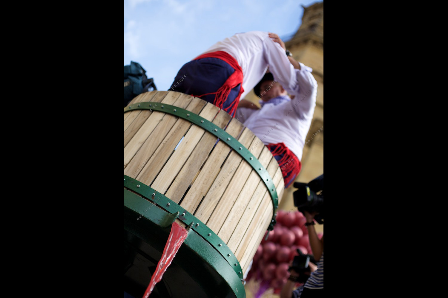 dos aldeanos en pose clásico, en el barril en el que se pisa la uva para extraer el zumo que se convertirá en vino