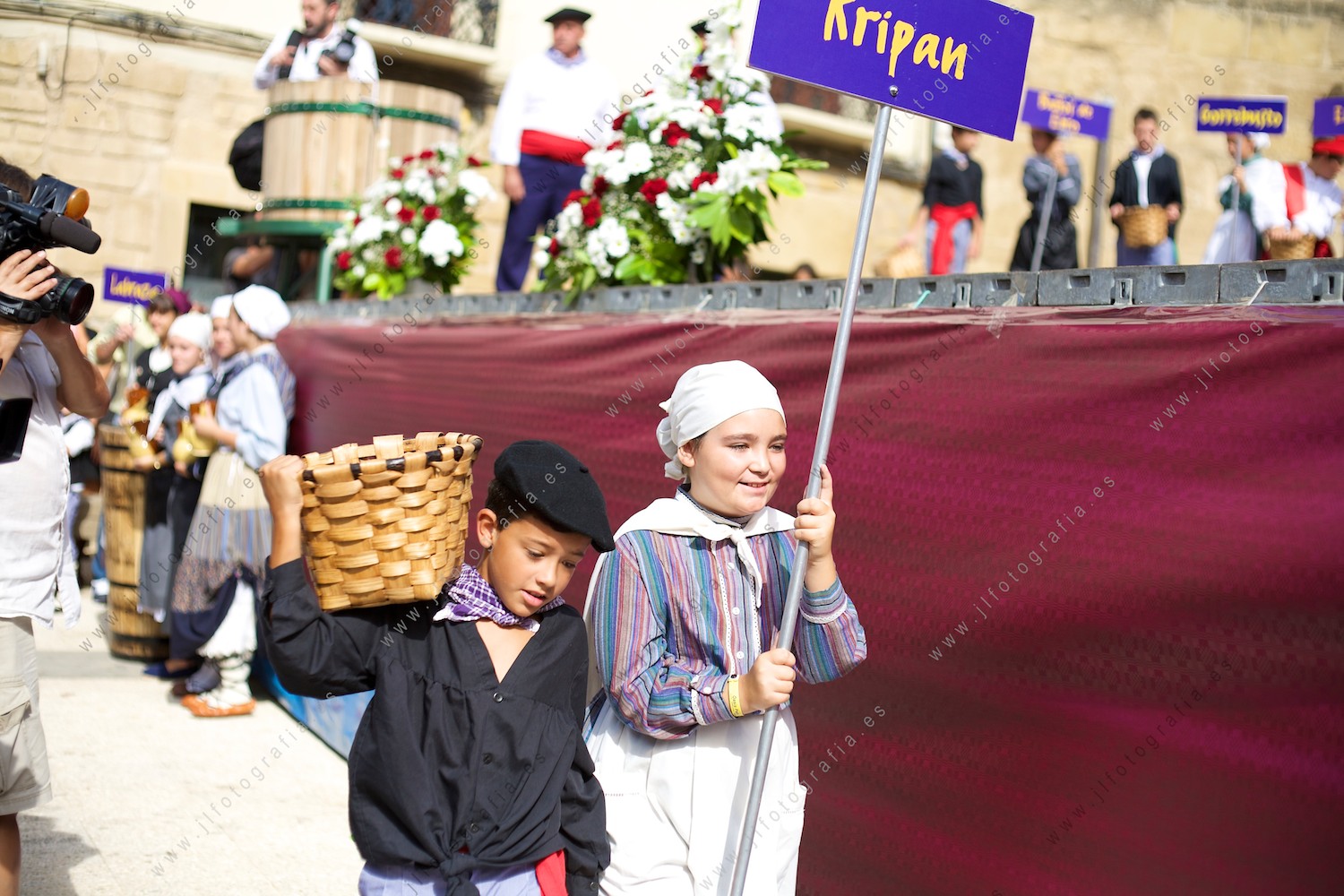 Dos niños llevan un cesto de uvas en representación de Kripan en la fiesta de la vendimia de Labastida