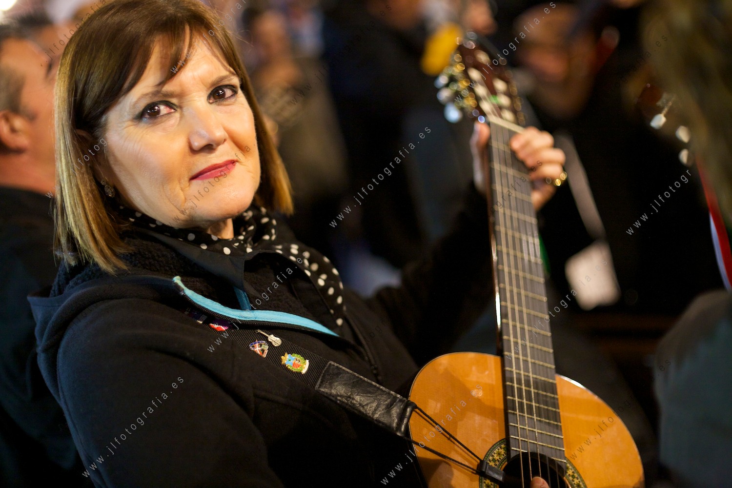 Retrato de primer plano de una señora tocando la guitarra.