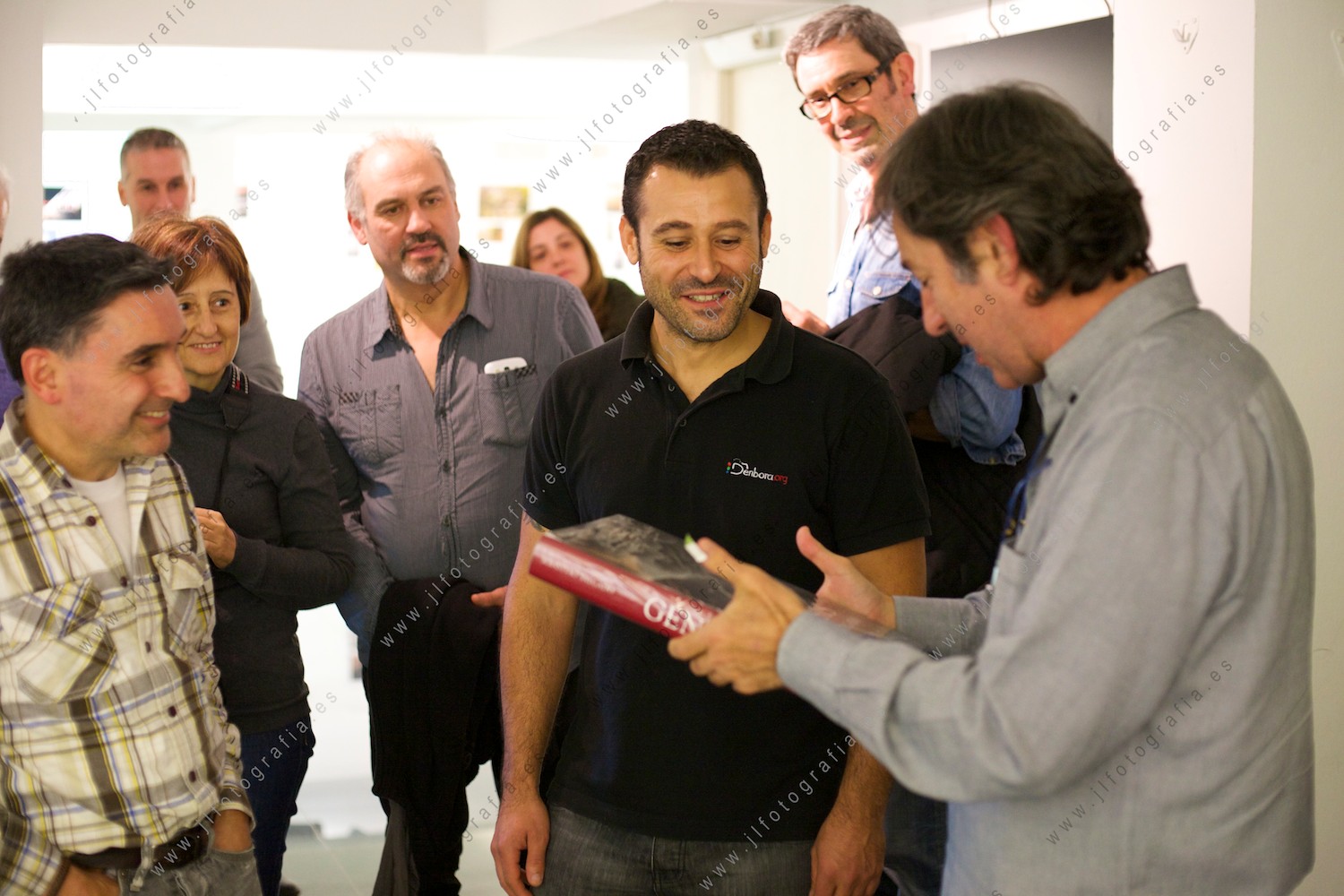 Juan Torre, fotógrafo de prensa, recibiendo el libro Génesis de Sebastiao Salgado, de manos de un socio de Denbora 