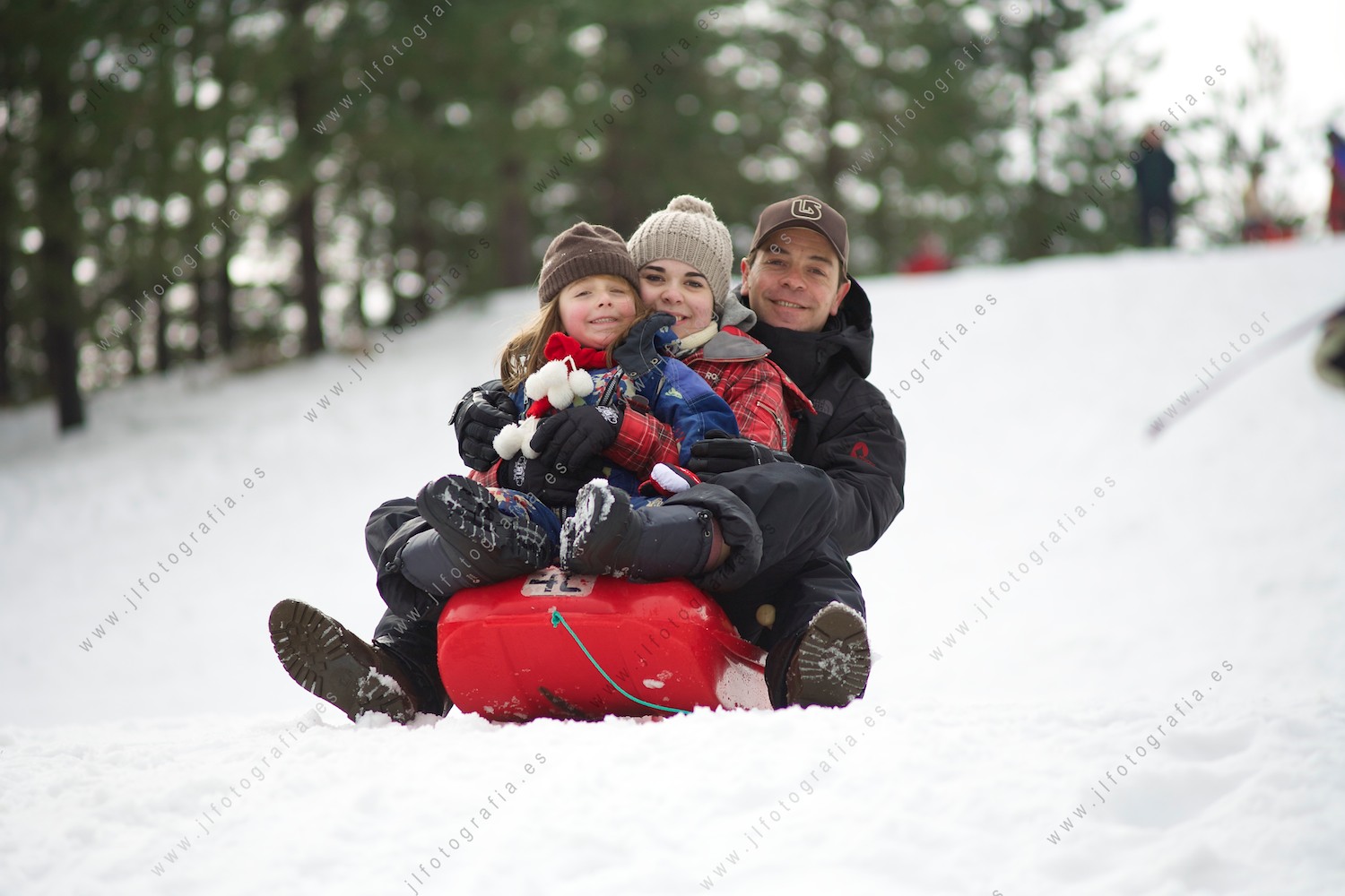 Familia montada en un trineo en la nieve para disfrutar del viaje