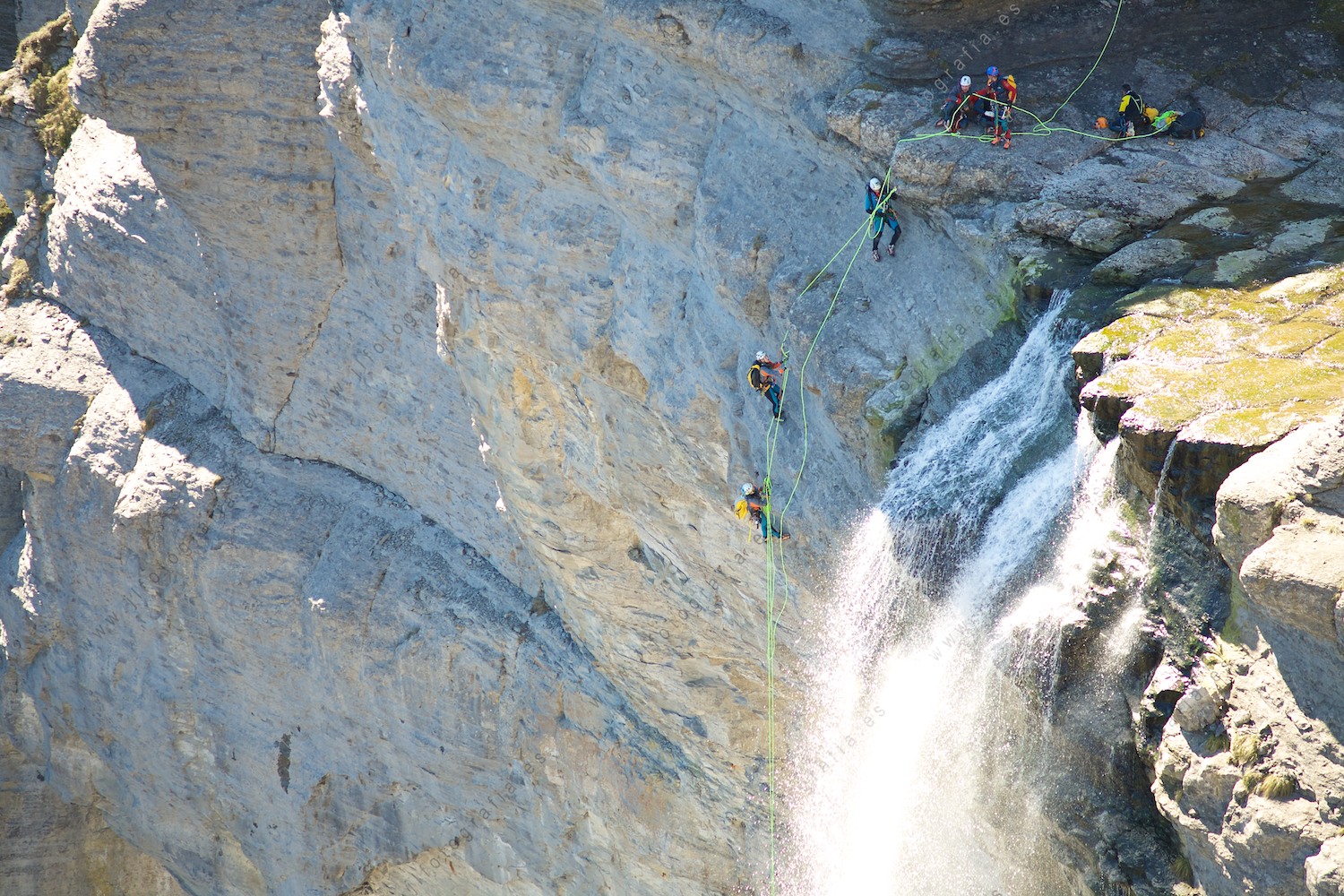 Detalle del salto del Nervión con montañeros iniciando el descenso por su pared