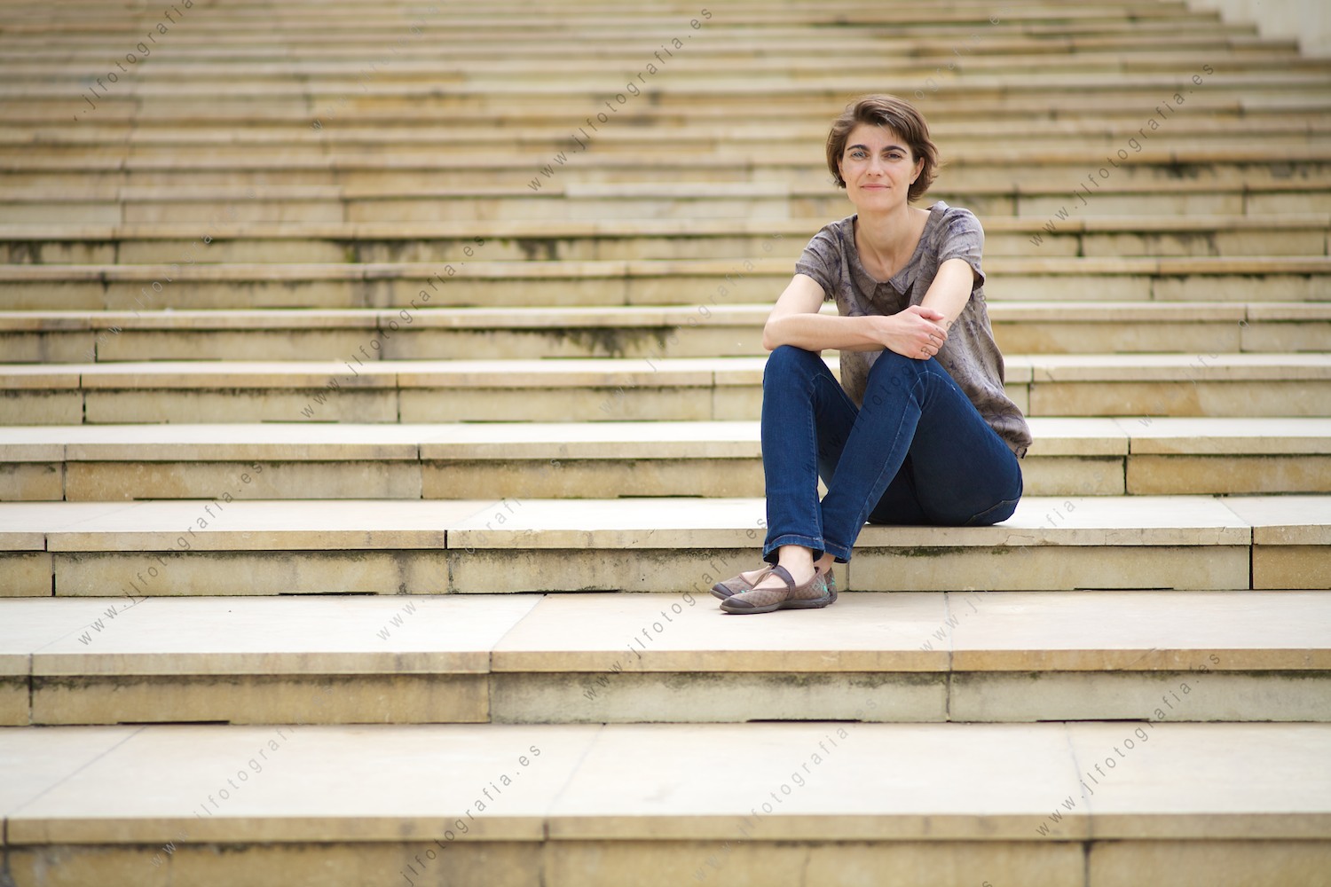 Rosa Martínez, plano general sentada en las escaleras del museo de arte contemporaneo Guggenheim Bilbao