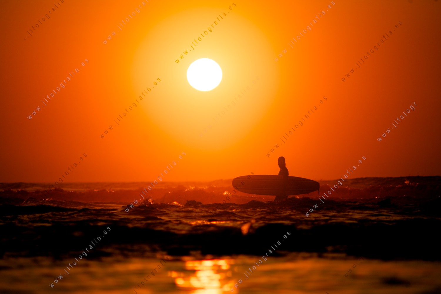 Surfista con su tabla bajo el sol de verano en Sopelana