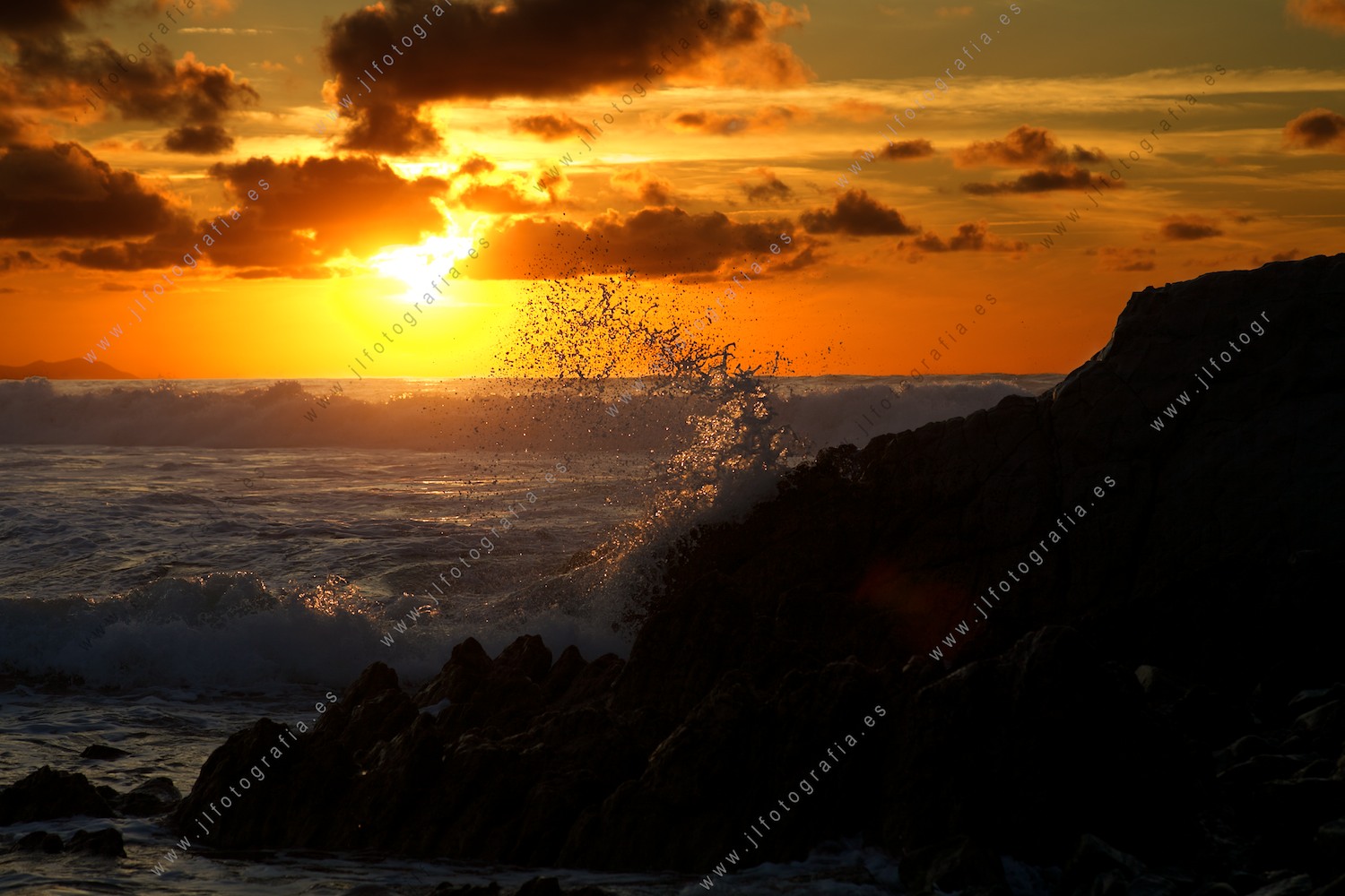 Olas golpeando contra las rocas en la playa de Sopelana durante la puesta de sol
