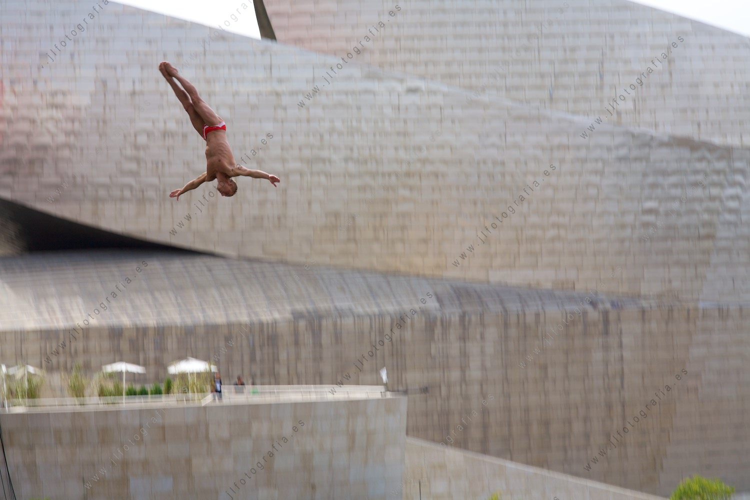 Precioso posado durante el salto del clavadistas en el Red Bull Cliff Diving en Bilbao con el museo Guggenheim al fondo