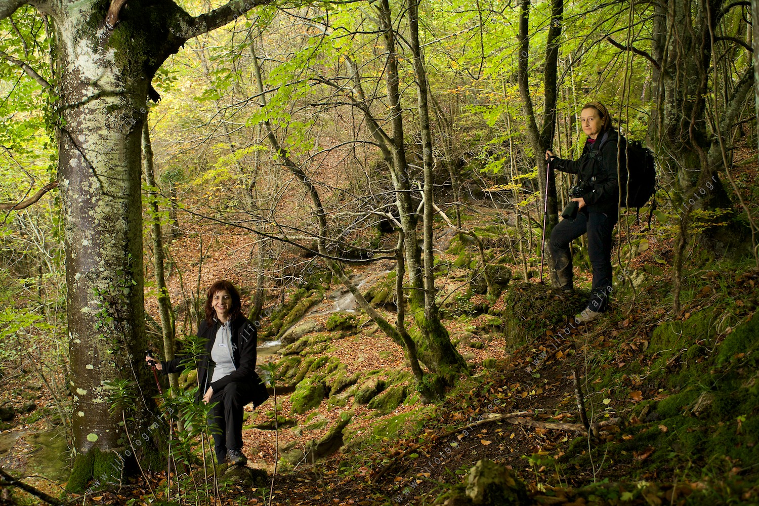 Dos amigas fotógrafas de la asociación fotográfica Denbora posando en el bosque de hayas delante de las cascadas de Tobería.