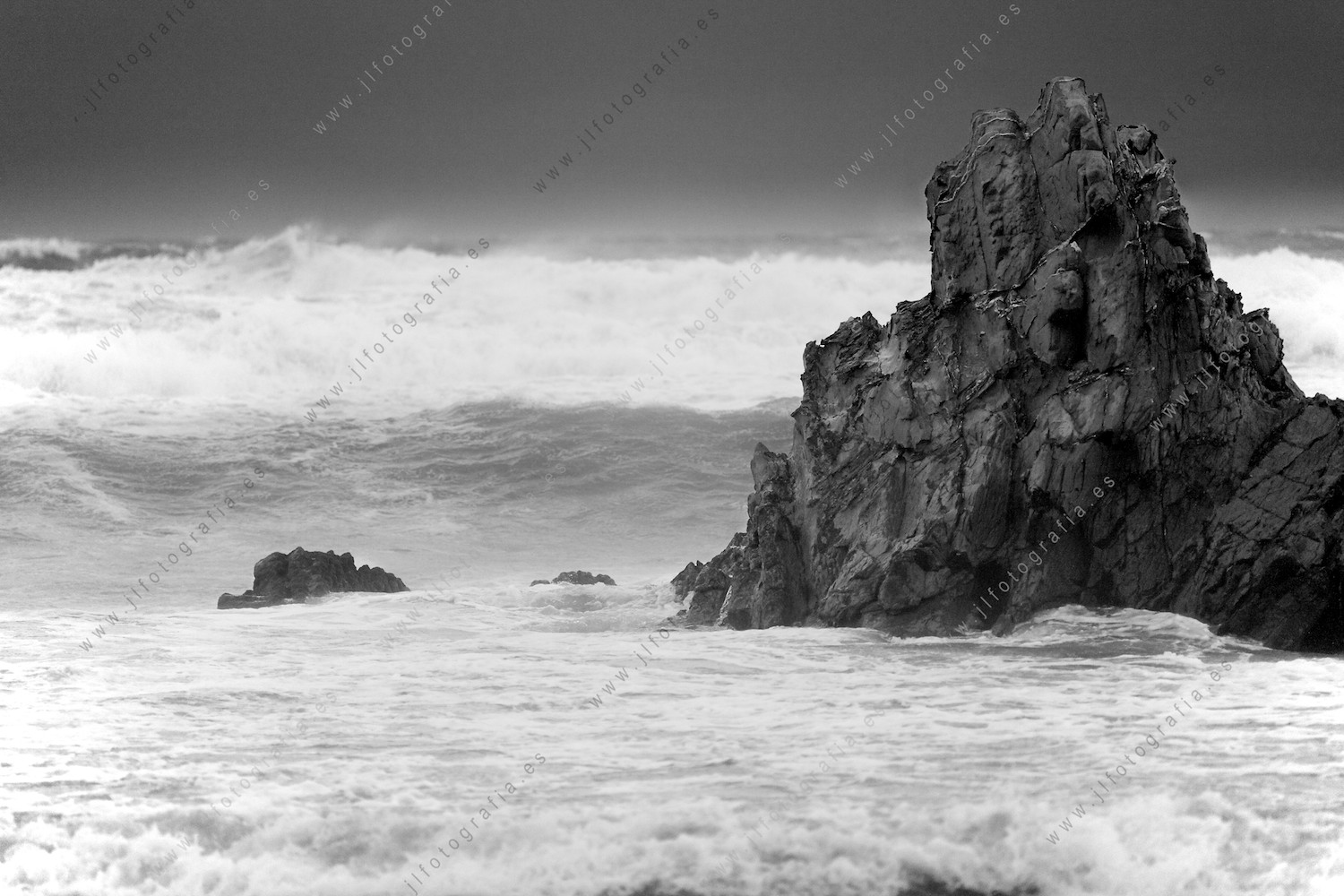 Una formación rocosa soporta las embestidas de las olas en la costa vasca, en Sopelana.