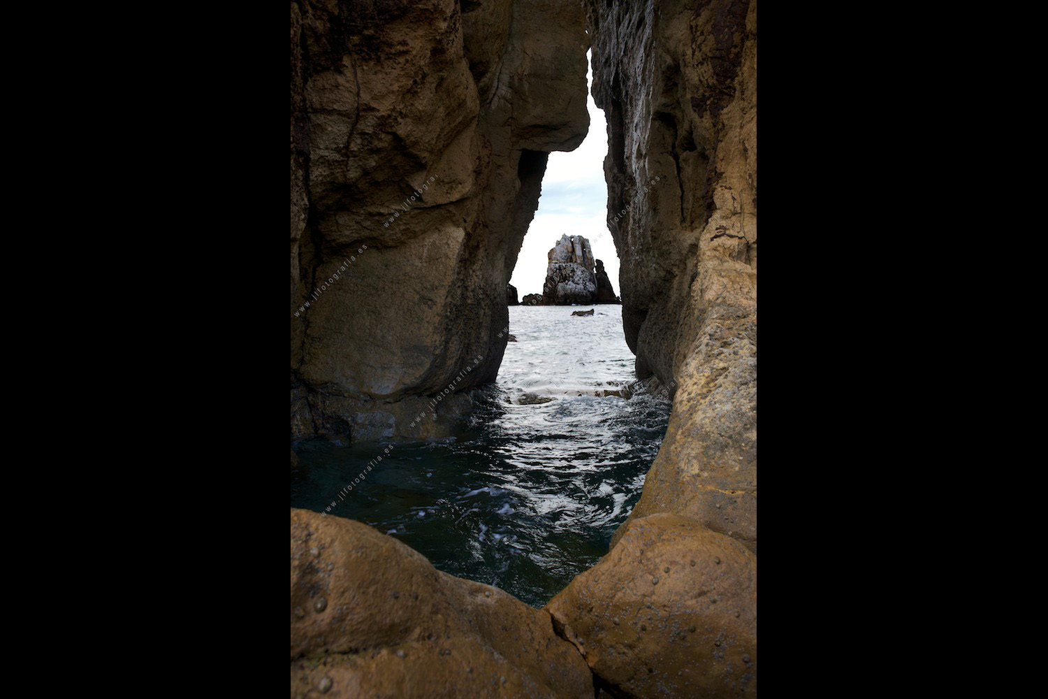 una fotografía apaisada de la formación de rocas Urro Menor en la Costa Quebrada, desde la playa del Porto en Liencres.