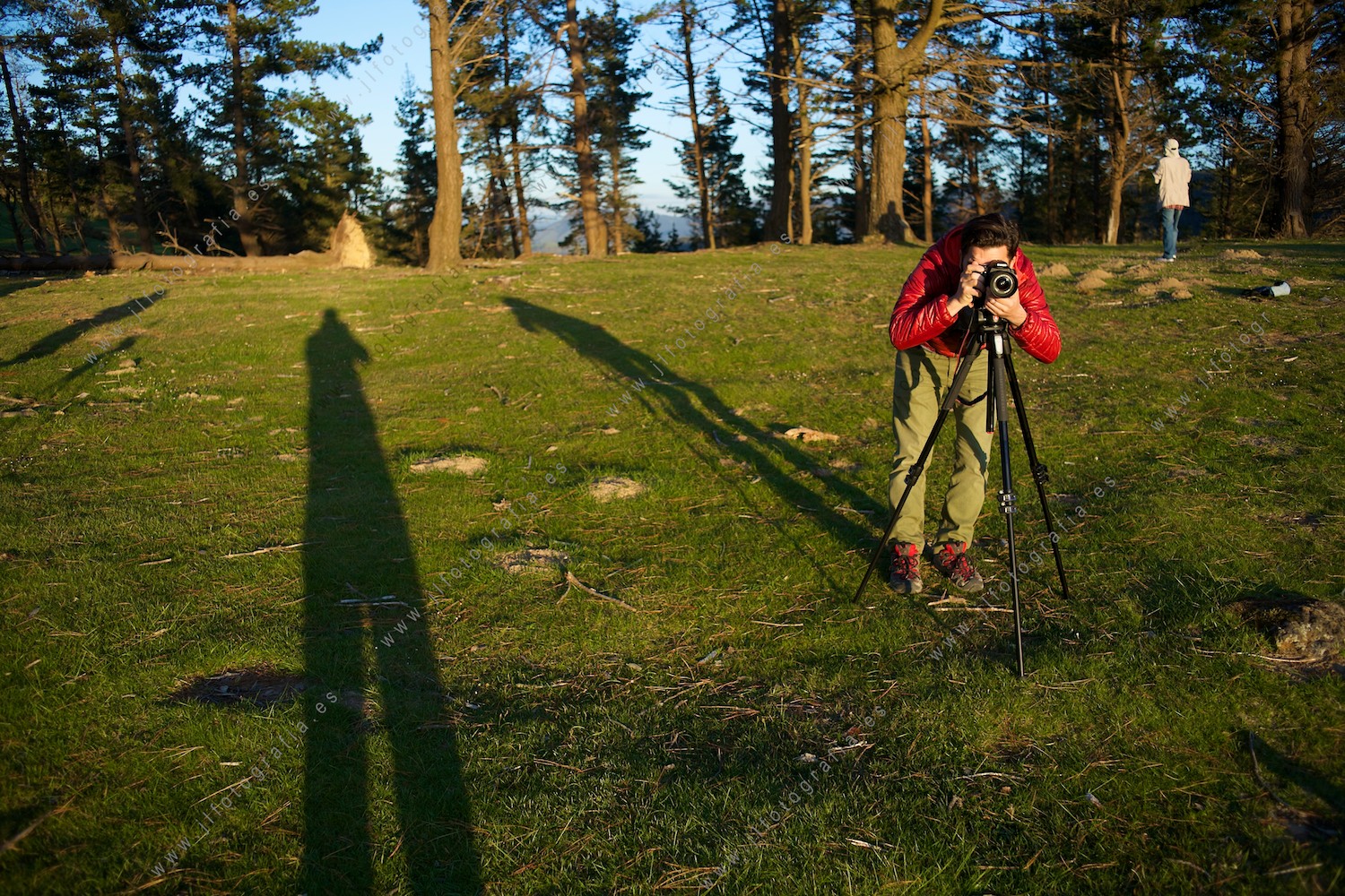 Un alumno de fotografía mira por el visor de su cámara en el trípode en clase de paisaje