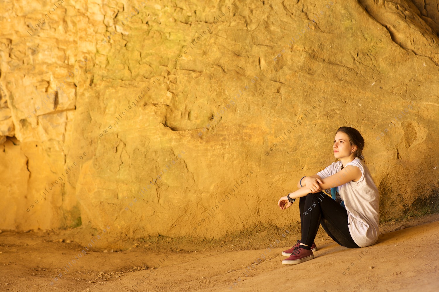 Una jovencita descansa en la cueva del Cañon del río Lobos, junto a la ermita.