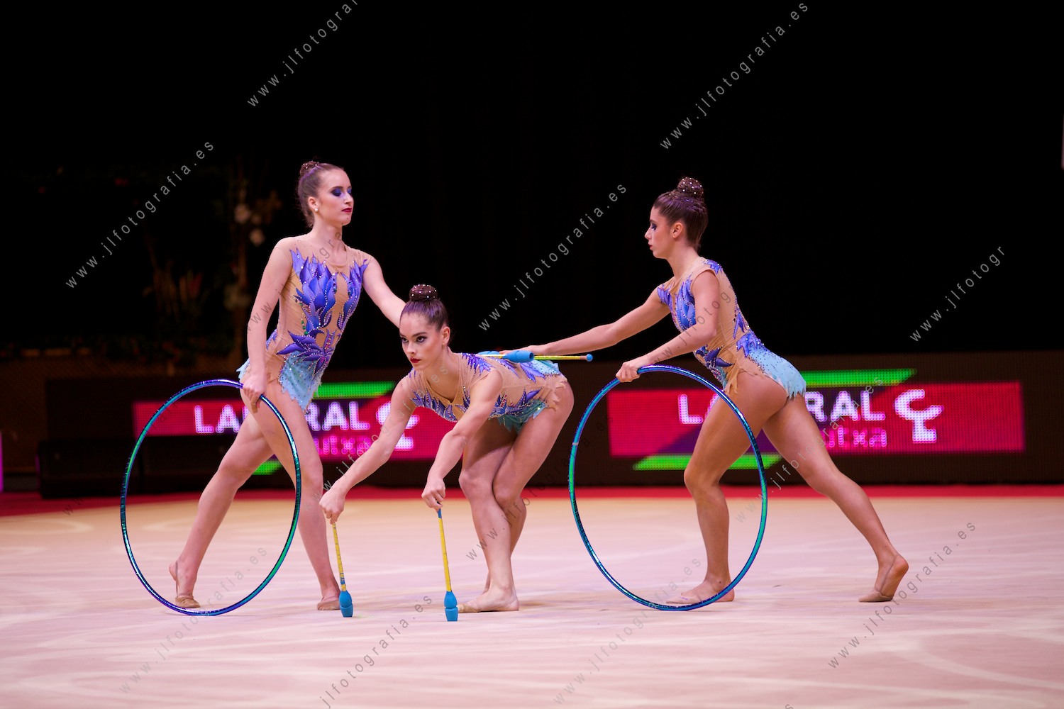Euskalgym 11 de 2016 en el Fernando Buesa Arena, trío de gimnastas en ejercicio con mazas y aros. .